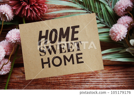 Home Sweet Home text message with flower decoration on wooden background Home Sweet Home text message with flower decoration on wooden background 105179176