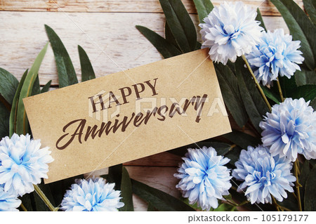 Happy Anniversary text message with flower decoration on wooden background Happy Anniversary text message with flower decoration on wooden background 105179177