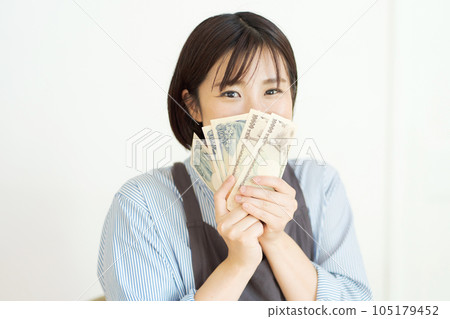 Photo of a smiling woman holding cash 105179452