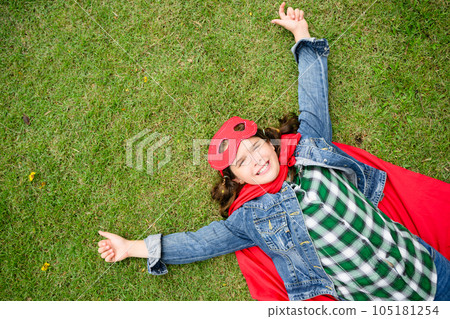 Active and cheerful girl with red coat and mask playing in green park Active and cheerful girl with red coat and mask playing in green park 105181254