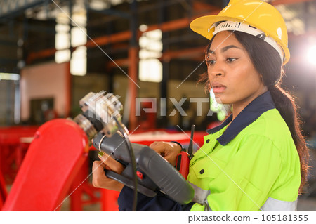 Professional female mechanical engineer in yellow hard hat and safety uniform 105181355