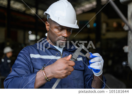 Professional male industrial worker in white hard hat working at manufacturing 105181644