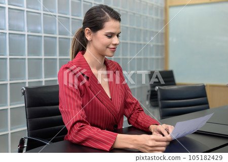 Happy businesswoman working with digital tablet at office Happy businesswoman working with digital tablet at office 105182429