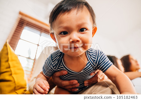Cute baby boy playing with father and mother at home 105182463