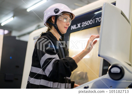 Professional technician checking part of automatic machine at factory Professional technician checking part of automatic machine at factory 105182713