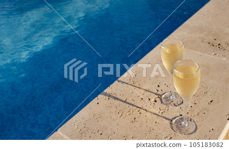 Cool glasses of champagne against poolside at resort hotel during vacation or weekend Cool glasses of champagne against poolside at resort hotel during vacation or weekend 105183082