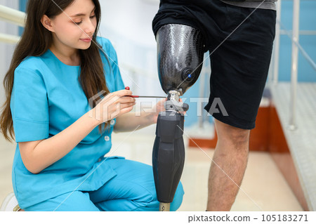 Physiotherapist adjusting prosthetic leg of patient in hospital 105183271