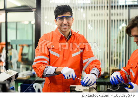 Engineers working and solving problems on machine at industrial plant 105183579