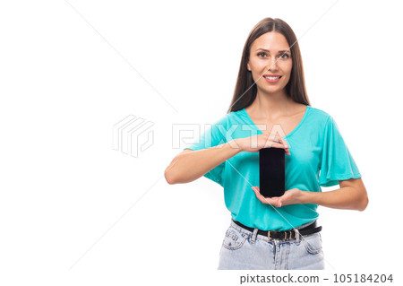 30 year old beautiful brunette woman with flowing straight hair in a blue t-shirt and jeans holds a 105184204