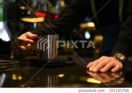 Close up of unrecognizable male barista weighing coffee beans on the electronic scales at coffee shop Close up of unrecognizable male barista weighing coffee beans on the electronic scales at coffee shop 105185706
