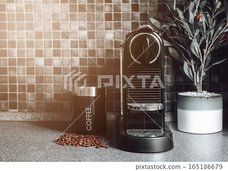 Black marble kitchen with home coffee machine and beans and morning sunlight 105186679