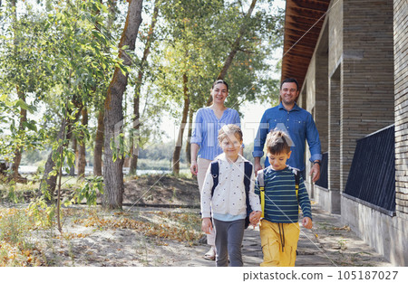 Young parents seeing their cute kids off to school 105187027