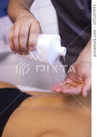 Close up of masseur hands with oil before start of session Close up of masseur hands with oil before start of session 105187043