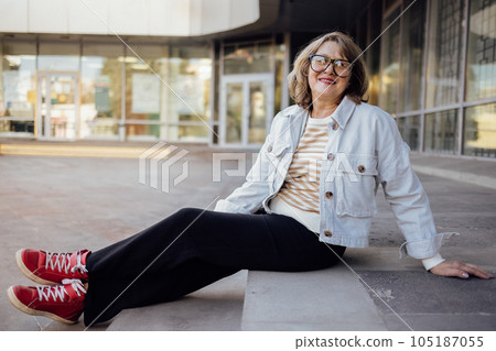 Senior woman in casual clothes laughs and looks into the camera Senior woman in casual clothes laughs and looks into the camera 105187055