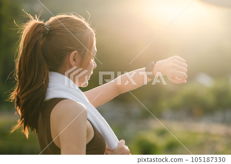Healthy woman relax after cool down and looking smart watch for check timing run. Woman workout after fitness and jogging session at the park. Healthy and Lifestyle Concept. Healthy woman relax after cool down and looking smart watch for check timing run. Woman workout after fitness and jogging session at the park. Healthy and Lifestyle Concept. 105187330
