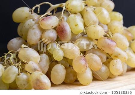 Green grapes unwashed lying on the board Green grapes unwashed lying on the board 105188356