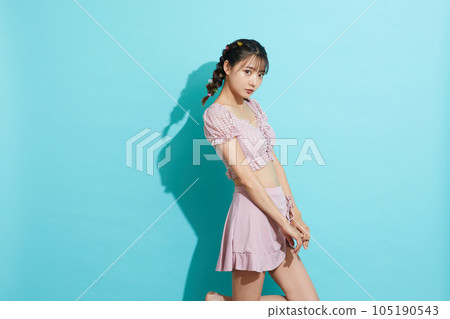 Blue background portrait of a young woman in a swimsuit Blue background portrait of a young woman in a swimsuit 105190543