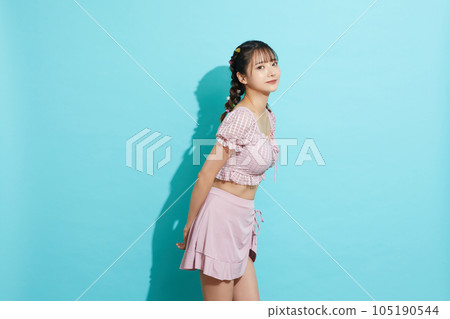 Blue background portrait of a young woman in a swimsuit Blue background portrait of a young woman in a swimsuit 105190544