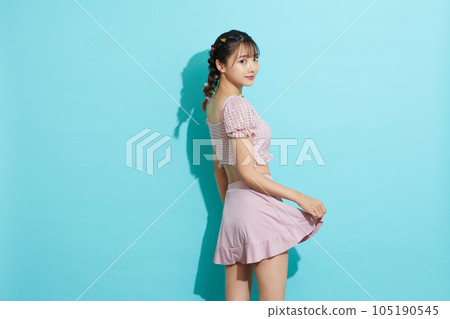 Blue background portrait of a young woman in a swimsuit 105190545
