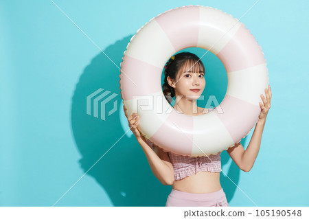 一位穿著泳衣的年輕女子的藍色背景肖像 一位穿著泳衣的年輕女子的藍色背景肖像 105190548