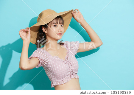 Blue background portrait of a young woman in a swimsuit Blue background portrait of a young woman in a swimsuit 105190589