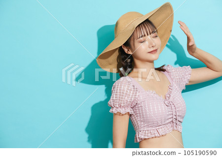 Blue background portrait of a young woman in a swimsuit Blue background portrait of a young woman in a swimsuit 105190590