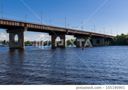 Bridge on a river against a blue sky and clouds 105190901