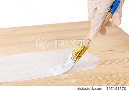 white paint with a brush painting a wooden background with texture 105191578
