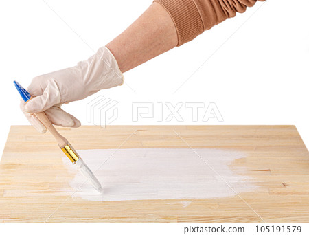 white paint with a brush painting a wooden background with texture 105191579