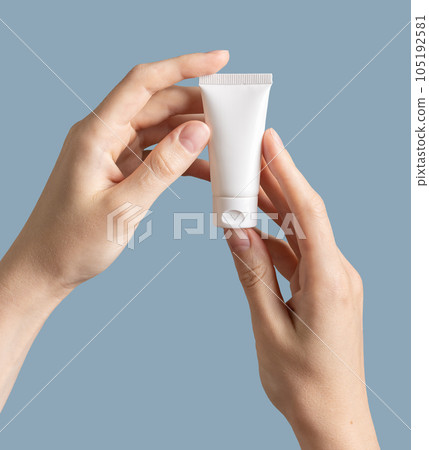 Hand holding cream tube isolated white background 105192581