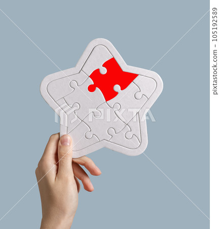Hand holding star shaped puzzle. Clients ranking, customers rating, negative opinion and feedback, reputation risks concept 105192589