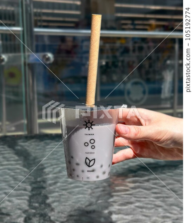 Hand holding taro tapioca drink, Asian bubble tea with straw 105192774