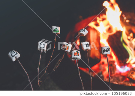 Marshmellows with Halloween pictures over fire. Funny leisure on traditional spooky holiday for children and families. 105196053