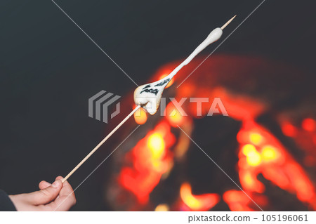 Marshmellows with Halloween pictures over fire. Funny leisure on traditional spooky holiday for children and families. 105196061