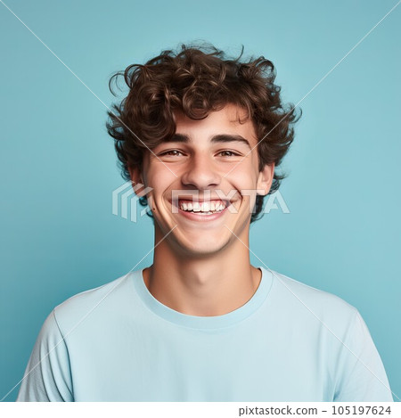 Portrait of a smiling young adult man with brown hair. Closeup face of a handsome young Caucasian man smiling at the camera on a blue background. Front view, happy young European man in a blue shirt. 105197624