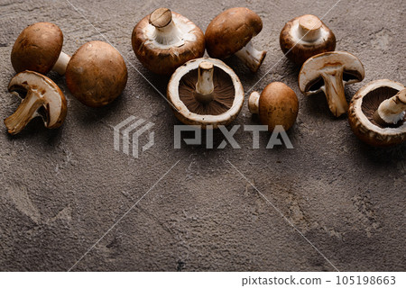 Raw champignon mushrooms on black background Raw champignon mushrooms on black background 105198663