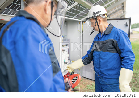 Two Service Engineers or electrician working on checking transformer site and solving problem for green energy solar power plant operation. Technician maintenance solar cells on Solar Energy Plant Two Service Engineers or electrician working on checking transformer site and solving problem for green energy solar power plant operation. Technician maintenance solar cells on Solar Energy Plant 105199381
