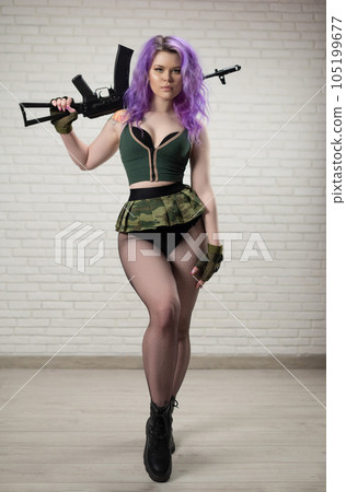 sexy girl with pink hair in a short skirt miliriti with an airsoft gun on a white background of a brick wall 105199677