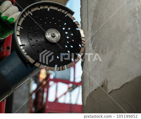 Master cuts a concrete wall with a circular diamond saw. Master cuts a concrete wall with a circular diamond saw. 105199852