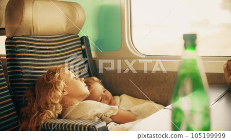 Two little sisters trying to get some sleep in the single high speed train seat 105199999