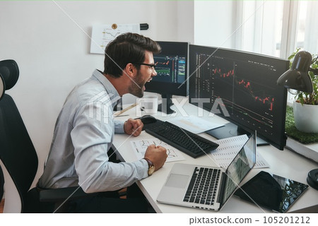 I am a winner Happy young trader in formalwear and eyeglasses shouting and feeling excited while looking at trading charts and financial data in the office. 105201212