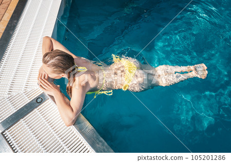 Woman enjoying water in swimming pool 105201286