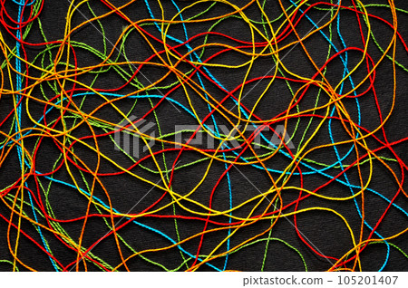 Multi-colored crochet-knitting threads tangled on a black background 105201407