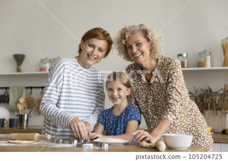 Happy kid, beautiful mom and grandma having fun and baking 105204725