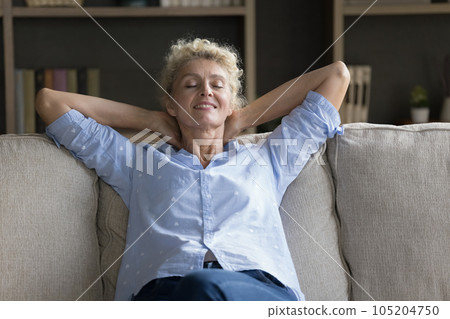Positive calm mature senior woman resting on couch 105204750