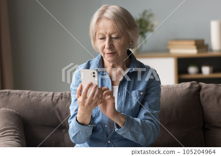 Focused woman read sms on cell phone Focused woman read sms on cell phone 105204964