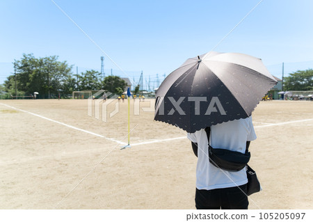 Woman watching children's soccer game 105205097