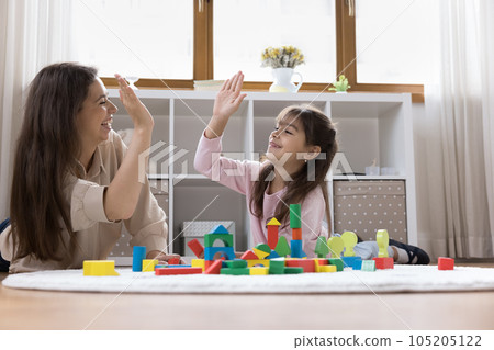 Happy mom and sweet preschool child girl giving high five Happy mom and sweet preschool child girl giving high five 105205122