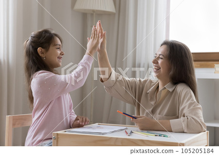 Cheerful mom and positive preschooler kid drawing in playroom together 105205184