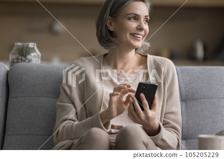 Happy pretty middle aged woman holding mobile phone, using application 105205229